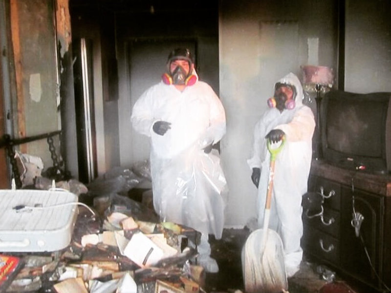 Maxi Serve crew in protective suits cleaning up after a fire