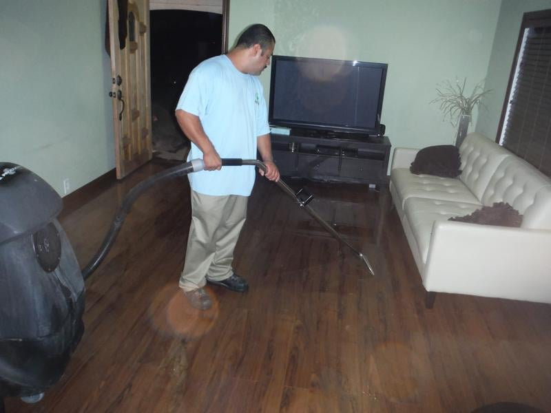 Technician extracting water from a flooded living room floor